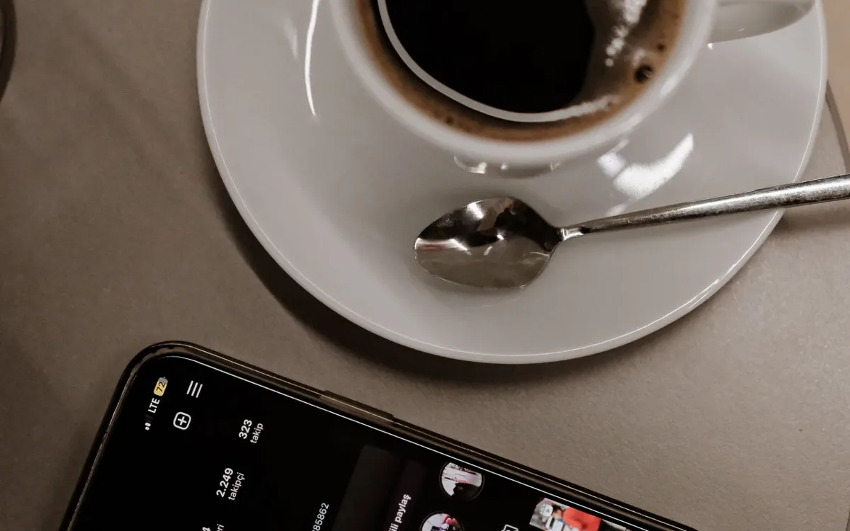 Taza de café y un celular sobre la mesa de un local